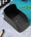 Waterproof Doorbell Cover Rain Guard in black plastic, showing interior design on a textured surface with stationery nearby