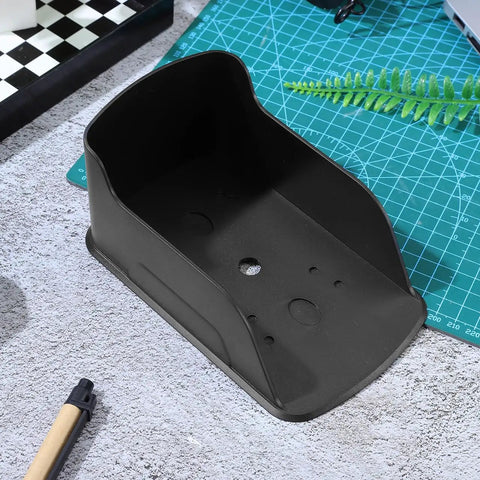 Waterproof Doorbell Cover Rain Guard in black plastic, showing interior design on a textured surface with stationery nearby