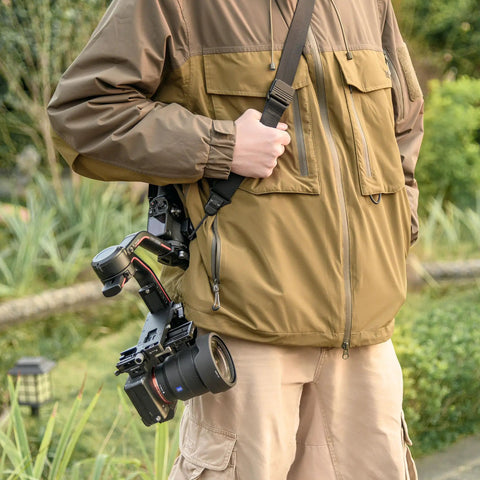 Person wearing Dual NATO Gimbal Strap for DJI RS 3 Pro RS 3 RS 2 and RSC 2, holding a camera outdoors.