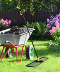 Heavy Duty Lawn Leveling Rake With 72 Inch Long Handle And 31 Inch Head Smooths Uneven Grass Fills Holes Level Soil next to wheelbarrow