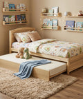Solid Pine Twin Bed Frame With Pull Out Trundle, natural wood finish, kids' room setup with playful bedding and plush toys.