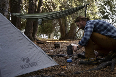 Man setting up camp with tent and Camping Hammock With 400 Lb Capacity And Heavy Duty Straps And Carabiners Navigator Series Pink