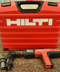DX 351 Fully Automatic Powder Actuated Tool With X MX32 Magazine, red, with ergonomic handle, in front of case