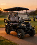 Sleek Black 4-Seater Electric Golf Cart With Raised Stance, Heavy Duty Shocks, Plug And Play Charging, Flex Cargo Trunk, 44 Mile Range Weekend Warrior Build For Parks And Hotel Runs parked on a golf course at sunset.