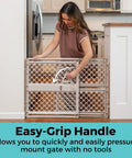 Woman using easy-grip handle on Top Shelf Adjustable Baby Gate For Kids And Toddlers Heavy Duty Plastic Child Safety Barrier.