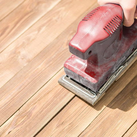 Hand using orbital sander on wood surface with All Purpose Sandpaper Set With 80 120 220 Grits 25 Sheets Of 9x11 Inches Cut To Fit Metal And Wood