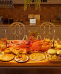 A cozy dining room illuminated by a Sunset Lamp Projector With RGB LED Lights, displaying a warm glow over a table set for a feast.