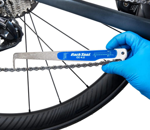 Using No Guesswork Bicycle Chain Wear Checker Pro Grade Gauge on bike chain for quick maintenance check.