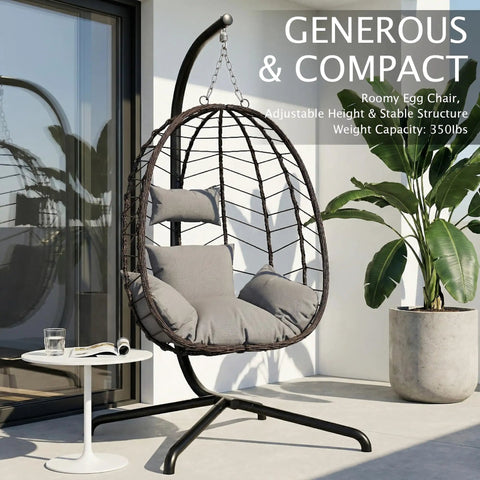 Grey hanging egg chair with stand for indoor and outdoor relaxation cozy wicker hammock lounge chair with cushion on patio.