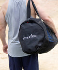 Person carrying XL Mesh Dive Duffel Bag for Scuba and Snorkeling Gear Heavy Duty Travel Duffle on a beach