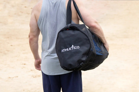 Person carrying XL Mesh Dive Duffel Bag for Scuba and Snorkeling Gear Heavy Duty Travel Duffle on a beach