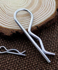 Extra Heavy Duty Stainless Steel Roll Pins 30 Piece Set For Pickup Trucks And Trailers Spring Retainer Clips showing large and small pins on wood.