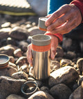 All In One Portable Coffee Maker With Vacuum Pressure Brew Hand Powered On The Go Coffee Brewer Insulated Stainless Steel Travel Mug 10 Ounce Thermo Cup Quick Fresh Brew For Commutes And Outdoors being assembled outdoors on rocks