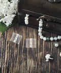 Slick All Purpose Acrylic Hinges For Jewelry Boxes And Crafts 10 Pack Small Piano Hinges on wooden surface with pearls