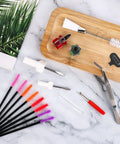 16 Piece Sewing Machine Cleaning Kit with dual head brush, tweezers, seam ripper, silicone brushes, and screwdrivers on marble.