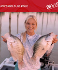 Angler holding two large fish caught with Buck's Gold Jig Pole in boat at sunset, showcasing successful fishing trip.