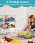 Child playing with toys in a room; clear stackable drawers storing colorful blocks and stuffed animals beside her.