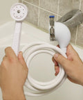 Person installing VersaSpray Portable Handheld Shower Sprayer For Bathtubs Without Diverter Fits Round Or Square Tub Spouts White 1 Pack