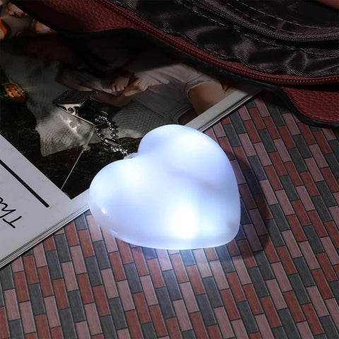 Two Pack Heart Shape Purse Lights With Sensor Illuminator For Handbags Battery Powered Night Light glowing on a surface