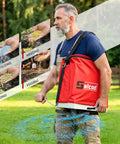 Man using Big 25 Lb Seed Spreader For Lawn And Garden, Adjustable Handheld Fertilizer And Grass Seed Spreader With Shoulder Strap