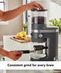 Premium Burr Coffee Grinder With Smart Dosing Technology For Dead Simple French Press To Espresso Ground Settings In Smooth Charcoal Grey Design, showcasing convenient use with freshly ground coffee.