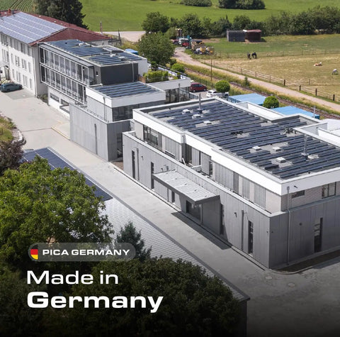 Aerial view of modern facility labeled 'Made in Germany,' showcasing PICA Germany solar-paneled buildings surrounded by greenery.