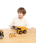 Child playing with Two Pack Remote Control Construction Vehicle Set With Friction Powered Excavator And Dump Truck Realistic Lights And Sounds