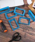 Six Pack Half Inch Single Gang Receptacle Box Extenders With Twelve Screws For Electric Boxes And Outlets That Stop Dents And Blend Into Any Wall Blue on table with tools