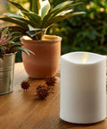 Outdoor Flameless LED Ivory Candle With Real Moving Flame And Melted Edge 3.75 Inch By 5 Inch Battery Operated Timer on a patio table