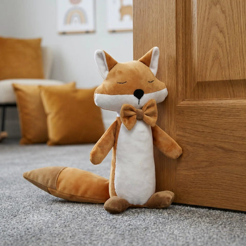 Fox Shaped Plush Door Stopper With Cotton Filling, Heavy Duty Proofing Pinch Guard next to a closed wood door in a cozy room.