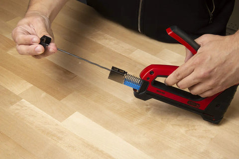 Heavy Duty Cable Boss Staple Gun Pro Grade For NM Coax And Low Voltage Wiring in use on wood surface