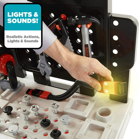 Close-up of Kids Power Tools Workshop Bench With 75 Realistic Tools, Lights And Sounds, showing a hand using a light-up drill tool.