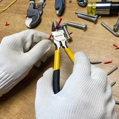 Close-up of BOOSDEN 6.5-inch wire cutters with yellow handles held by gloved hands