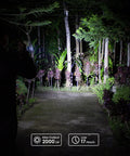 Person using SC32 Pocket Size EDC Flashlight 2000 Lumens Rechargeable SST40 LED 5000K at night in a garden path