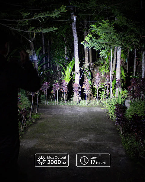 Person using SC32 Pocket Size EDC Flashlight 2000 Lumens Rechargeable SST40 LED 5000K at night in a garden path