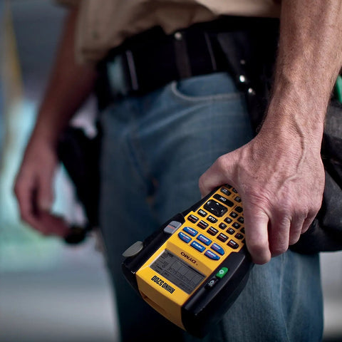 Person holding a Rhino 5200 Label Maker With One Touch Hot Keys For Speedy, Durable Asset Labeling On Job Sites