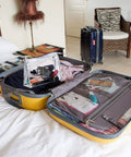 Open yellow suitcase on bed with clothing and Two Boxes Pre Threaded Hand Sewing Needles Kit With Colorful Threads For Quick Fixes inside