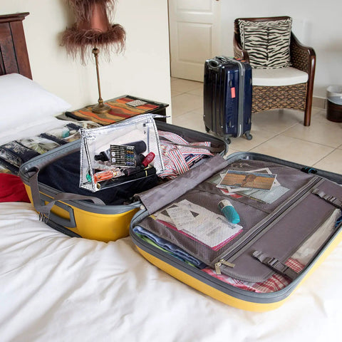 Open yellow suitcase on bed with clothing and Two Boxes Pre Threaded Hand Sewing Needles Kit With Colorful Threads For Quick Fixes inside