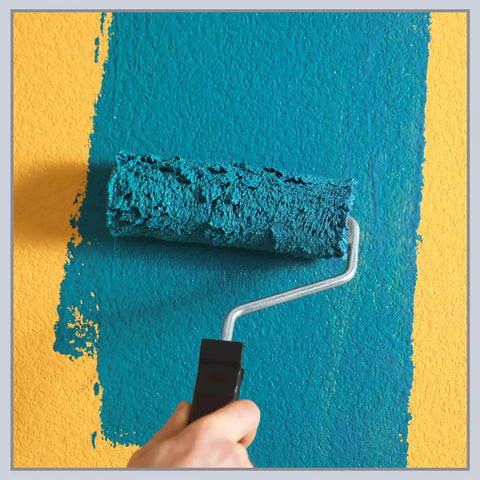 Hand rolling teal paint over yellow wall with textured roller
