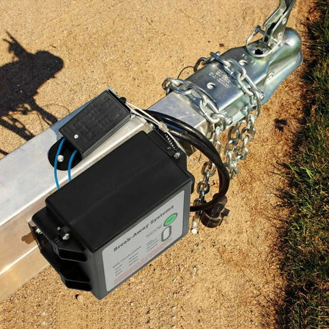 12V LED Trailer Breakaway Kit With Universal Brake Controls on trailer hitch with chains, black weatherproof case on sandy ground