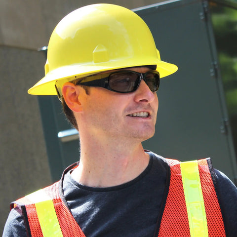 Worker wearing a Full Brim Safety Hard Hat With 8 Point Ratchet Suspension, Lightweight HDPE Construction, High Visibility Yellow.
