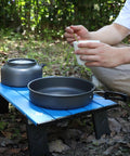 Ultralight Folding Beach Table For Camping And Picnics Portable Aluminum Side Table with cookware outdoors in a park setting.
