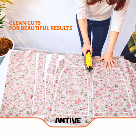 Slick Cordless Electric Fabric Scissors And Heavy Duty Cardboard Cutter With Two Swappable Blades cutting floral fabric for sewing.