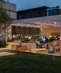 Colorful solar pathway lights with star and moon shapes illuminating a modern patio garden at dusk.