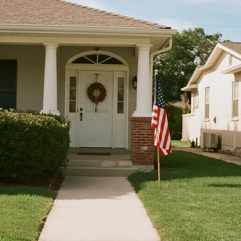 Heavy Duty 3x5 Foot Outdoor US Flag With Embroidered Stars And Sewn Stripes Durable 210D Polyester For All Weather Use Brass Grommets Indoor Or Outdoor Display in front of a house.