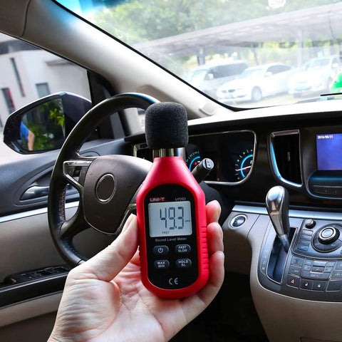 UT353 Decibel Meter Portable Digital Sound Level Meter 30 To 130 dB With Max Min Fast Slow Data Hold LCD Backlit Auto Power Off Lightweight Ergonomic Design For On The Go in a car interior, handheld reading 49.3 dBA