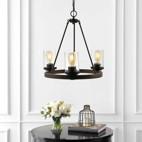 Oil Rubbed Bronze 20 Inch Three Light Rustic Farmhouse LED Chandelier With Wagon Wheel Design hanging over a table with flowers.