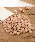 120Pcs Wooden Screw Hole Plugs for Furniture With Mushroom Head Covers spilling from a white bag on a wooden surface