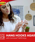 Woman applying Medium Refill Replacement Strips for Damage Free Hanging on Small Wall Hooks, white 9 strips pack, easy adhesive solution.