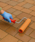 Using a paint roller on paver stones with Straight Up Hella Durable Crystal Clear Paver Sealer And Concrete Masonry Guard Water Based Acrylic Coating That Locks Out Grime And Keeps Patios Looking Fresh In A Five Gallon Size.